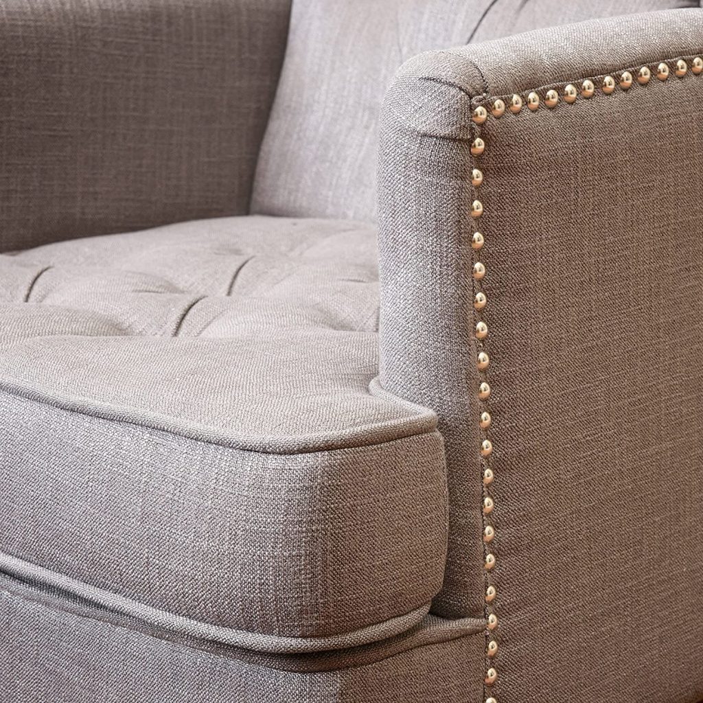 beige club chair - close up view of studded trim, arm, and tufted seat